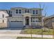 Beautiful two story home featuring a gray exterior with white brick accents, and a two car garage at 647 Nightsky St, Erie, CO 80516