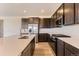 Modern kitchen featuring dark cabinets, white countertops, stainless steel appliances, and a gas range at 647 Nightsky St, Erie, CO 80516