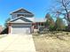 Two-story home with a brick front, gray siding, and an attached two-car garage at 4996 S Gibraltar Way, Centennial, CO 80015