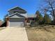 Charming two-story home with a well-maintained lawn, a covered front porch, and an attached two-car garage at 4996 S Gibraltar Way, Centennial, CO 80015