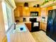 An eat-in kitchen with wood cabinets, black appliances and a large window over the sink at 4996 S Gibraltar Way, Centennial, CO 80015