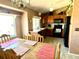 An eat-in kitchen with wood cabinets, black appliances and a large window over the sink that opens into the dining area at 4996 S Gibraltar Way, Centennial, CO 80015