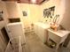 A charming laundry room with washer, dryer, utility sink, and quirky posters at 4996 S Gibraltar Way, Centennial, CO 80015