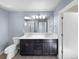 Bathroom featuring double sinks, a large mirror, ample countertop space, and tiled floors at 591 Brennan Cir, Erie, CO 80516