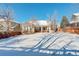 Spacious backyard with snow-covered lawn and wooden fence at 3016 Greensborough Dr, Highlands Ranch, CO 80129