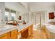 Elegant bathroom with double sinks, a large soaking tub, and a walk-in shower at 3016 Greensborough Dr, Highlands Ranch, CO 80129