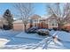 Beautiful two-story home with snow-covered landscaping and attached garage at 3016 Greensborough Dr, Highlands Ranch, CO 80129