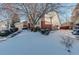 Brick house with a large tree in the front yard, covered in snow at 3016 Greensborough Dr, Highlands Ranch, CO 80129