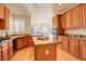 Spacious kitchen with wood cabinets, granite counters, and an island at 3016 Greensborough Dr, Highlands Ranch, CO 80129