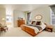 Main bedroom with ensuite bath, a king bed, and built-in wooden dresser at 3016 Greensborough Dr, Highlands Ranch, CO 80129