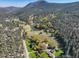 Aerial view of a lush mountain community featuring ponds, fields, and luxurious homes at 33884 Bergen View Trl, Evergreen, CO 80439