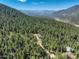 Beautiful aerial view of wooded lot with mountain views and a modern home at 33884 Bergen View Trl, Evergreen, CO 80439
