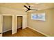 Cozy bedroom with hardwood floors, ceiling fan, closet, and bright window with wooded views at 33884 Bergen View Trl, Evergreen, CO 80439