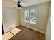 Cozy bedroom with hardwood floors, ceiling fan, and large window with views of the forest at 33884 Bergen View Trl, Evergreen, CO 80439