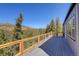 Spacious deck with wood railing offers tranquil views of trees and distant mountains at 33884 Bergen View Trl, Evergreen, CO 80439