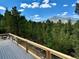 Stunning deck with wood railing offers incredible views of the surrounding forest at 33884 Bergen View Trl, Evergreen, CO 80439