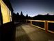 Enjoy this spacious deck with beautiful mountain views at twilight, perfect for outdoor entertaining at 33884 Bergen View Trl, Evergreen, CO 80439