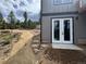 Newly constructed home with gray siding and white French doors with a natural wooded lot at 33884 Bergen View Trl, Evergreen, CO 80439