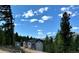 Charming home nestled among trees with a beautiful blue sky backdrop at 33884 Bergen View Trl, Evergreen, CO 80439