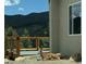 A relaxing deer rests outside this mountain house with stone accents and a wood deck at 33884 Bergen View Trl, Evergreen, CO 80439