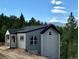 Modern home exterior featuring a sleek design and complementary gray tones, nestled in a forest setting at 33884 Bergen View Trl, Evergreen, CO 80439