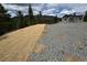 Exterior view of the home with a gravel driveway and surrounding landscape at 33884 Bergen View Trl, Evergreen, CO 80439