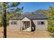 Charming single-story home with modern front door and neutral siding surrounded by beautiful mountain views at 33884 Bergen View Trl, Evergreen, CO 80439