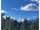 Scenic landscape view featuring the surrounding mountains and a bright blue sky with scattered clouds at 33884 Bergen View Trl, Evergreen, CO 80439