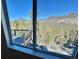 Stunning mountain views from a large window with an adjacent deck at 33884 Bergen View Trl, Evergreen, CO 80439
