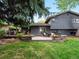 Lush backyard featuring a patio with a dining area, a fire pit, and well-maintained landscaping at 7055 E Heritage S Pl, Centennial, CO 80111