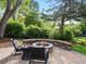 Inviting backyard with a cozy stone fire pit, comfortable seating, and lush landscaping at 7055 E Heritage S Pl, Centennial, CO 80111