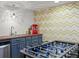 Basement game area featuring foosball table, wet bar with sink, and bright zig zag patterned wall paper at 7055 E Heritage S Pl, Centennial, CO 80111