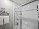 Bright bathroom showcasing a clean shower/tub combo with clear glass doors and elegant white tile at 7055 E Heritage S Pl, Centennial, CO 80111