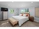 Bright bedroom with a queen bed, two windows, and neutral décor at 7055 E Heritage S Pl, Centennial, CO 80111