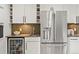 Sleek kitchen featuring stainless steel refrigerator, wine storage, and tiled backsplash at 7055 E Heritage S Pl, Centennial, CO 80111