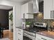 Well-equipped kitchen with stainless steel oven, hood, mosaic backsplash and white cabinetry at 7055 E Heritage S Pl, Centennial, CO 80111