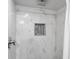 Luxurious shower featuring rain shower head, marble-style tile, and a stylish niche for bathroom products at 7055 E Heritage S Pl, Centennial, CO 80111