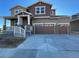 Two-story house with a brown and beige exterior, two-car garage, and a front porch at 4664 Windmill Dr, Thornton, CO 80601