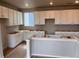 Spacious kitchen featuring white cabinets, a large window, and an unfinished island at 2261 Peregrine Dr, Brighton, CO 80601