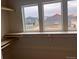 Walk-in closet featuring three windows looking out at neighboring houses in a new community at 2261 Peregrine Dr, Brighton, CO 80601