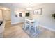 Charming dining area with a view of the kitchen, a white table, and hardwood flooring at 14006 E Stanford Cir # K08, Aurora, CO 80015