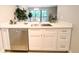 Stylish kitchen with stainless steel dishwasher, white cabinets, and modern countertops at 14006 E Stanford Cir # K08, Aurora, CO 80015