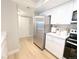Modern kitchen featuring stainless steel appliances, white cabinets, and light-colored flooring at 14006 E Stanford Cir # K08, Aurora, CO 80015
