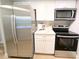 Modern kitchen featuring stainless steel appliances, white cabinets, and hardwood flooring at 14006 E Stanford Cir # K08, Aurora, CO 80015