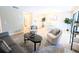 Open concept living room with dining area, wood floors, and modern accents at 14006 E Stanford Cir # K08, Aurora, CO 80015