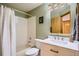 Full bathroom featuring tub with shower, white vanity, and large, framed mirror at 10762 W 54Th Pl, Arvada, CO 80002