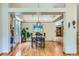 Bright dining room with hardwood floors, modern light fixture, and an open floor plan at 10762 W 54Th Pl, Arvada, CO 80002
