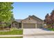 Charming home featuring a three-car garage, brick facade, front porch, and a well-maintained lawn at 10762 W 54Th Pl, Arvada, CO 80002