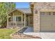 Attractive exterior with a well-kept lawn, brick accents, and a cozy porch at 10762 W 54Th Pl, Arvada, CO 80002