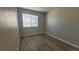 Cozy bedroom featuring a window with blinds and wood-look floors at 10890 W Evans Ave # 2E, Lakewood, CO 80227